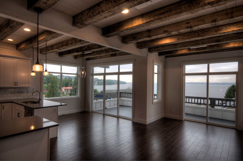 Imagen de salón abierto actual grande con paredes beige y suelo de madera oscura