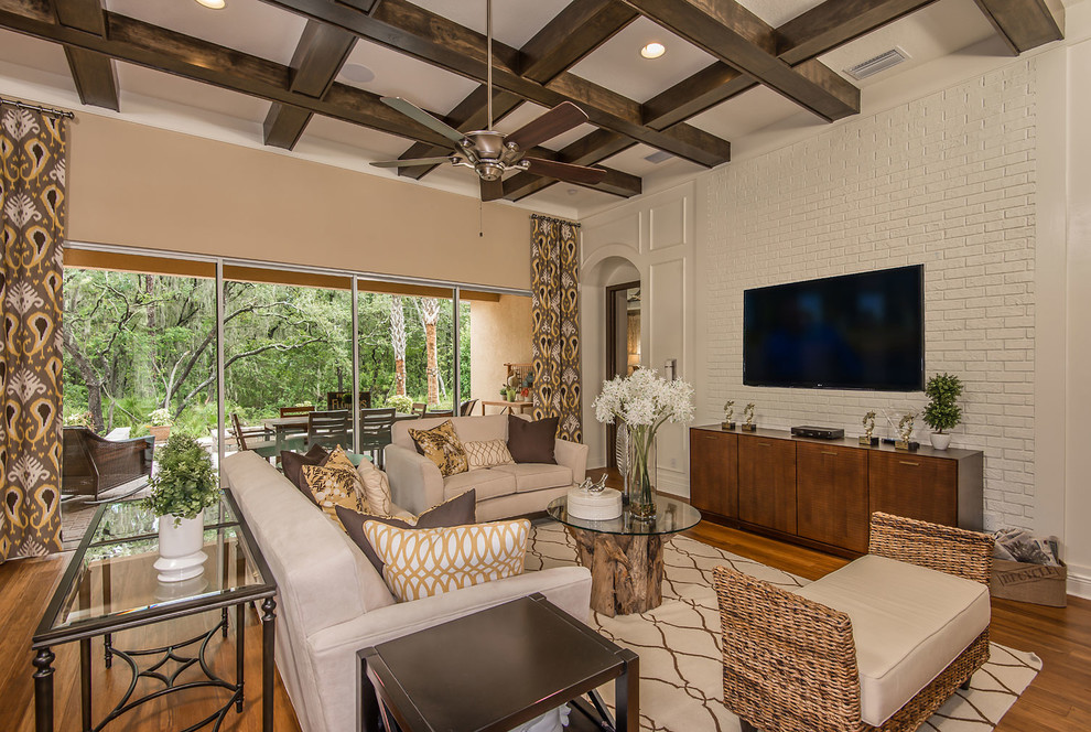 Diseño de salón abierto clásico renovado con paredes beige, suelo de madera en tonos medios y televisor colgado en la pared