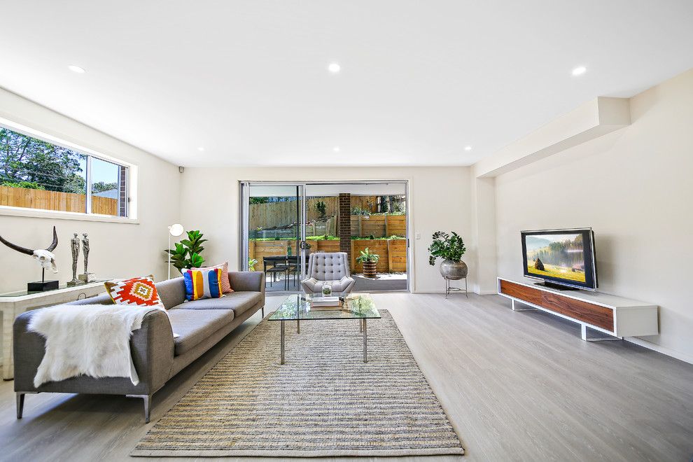 Идея дизайна: парадная, изолированная гостиная комната в современном стиле с бежевыми стенами, светлым паркетным полом, отдельно стоящим телевизором и серым полом