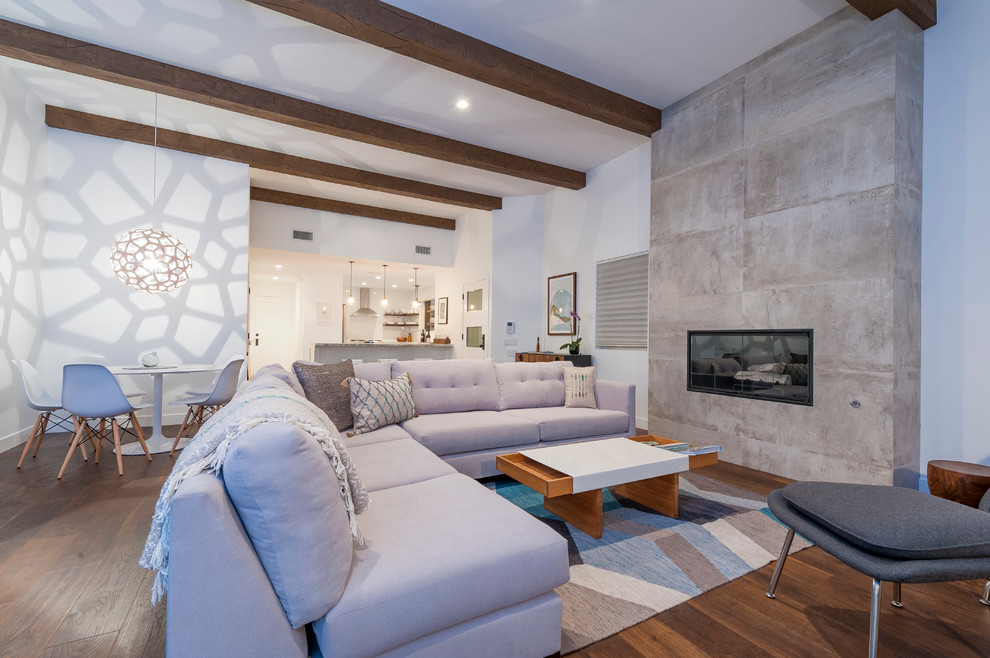 Offenes Maritimes Wohnzimmer mit weißer Wandfarbe, Gaskamin, Kaminumrandung aus Beton und braunem Holzboden in San Diego