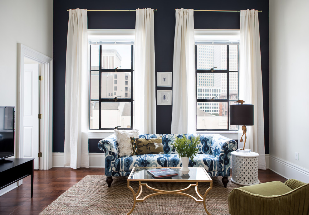 Klassisches Wohnzimmer mit blauer Wandfarbe, braunem Holzboden, freistehendem TV und braunem Boden in New Orleans