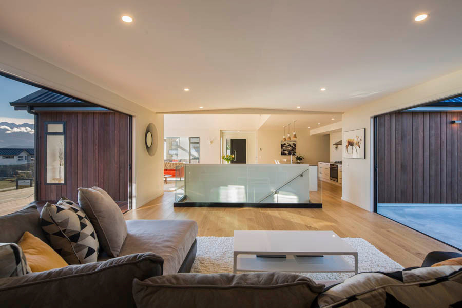 Modelo de salón abierto minimalista de tamaño medio con paredes blancas, suelo de madera clara y suelo beige