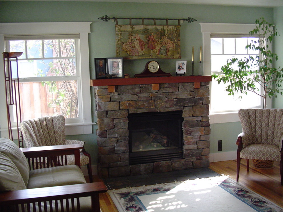 Foto di un soggiorno american style di medie dimensioni e chiuso con pareti verdi, pavimento in legno massello medio e cornice del camino in pietra