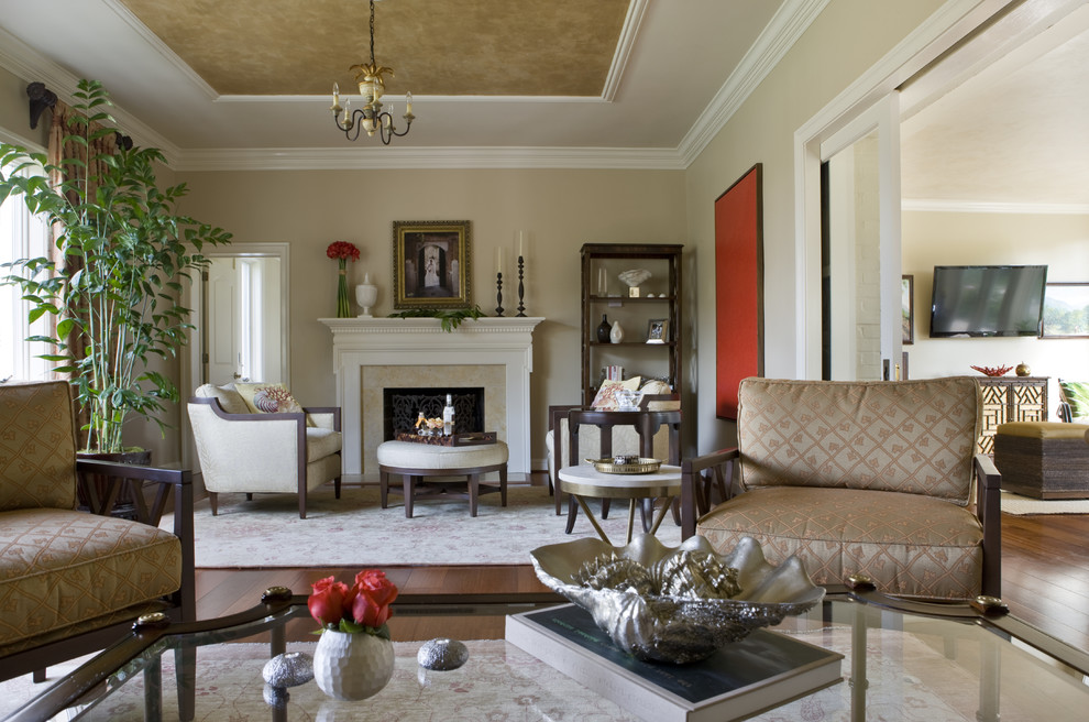 Ejemplo de salón tradicional con paredes beige, suelo de madera en tonos medios, todas las chimeneas y marco de chimenea de piedra