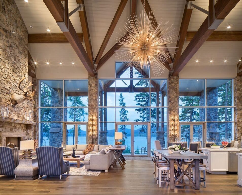 Inspiration for a large rustic formal open plan living room in Other with white walls, medium hardwood flooring, a standard fireplace, a stone fireplace surround, no tv, brown floors and feature lighting.
