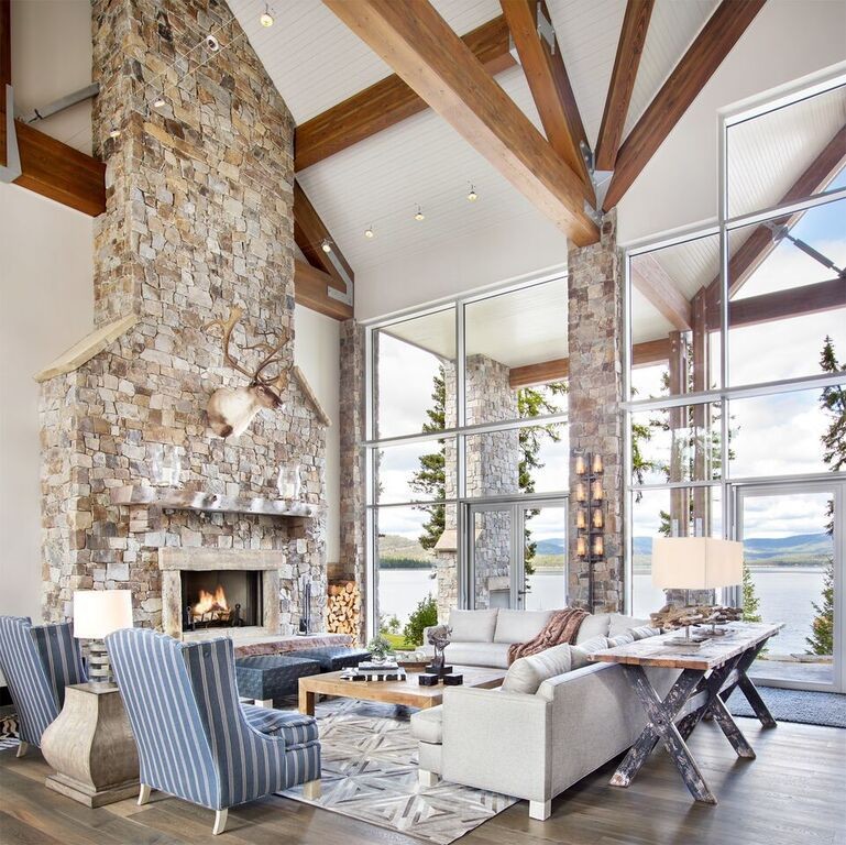 Large mountain style formal and open concept medium tone wood floor and brown floor living room photo in Other with white walls, a standard fireplace, a stone fireplace and no tv