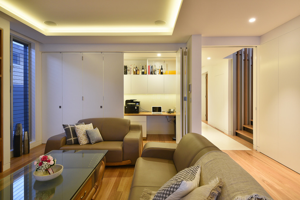 Cette photo montre un grand salon moderne ouvert avec un mur blanc, une cheminée ribbon, un manteau de cheminée en pierre, un téléviseur encastré, une salle de réception, parquet clair et un sol marron.