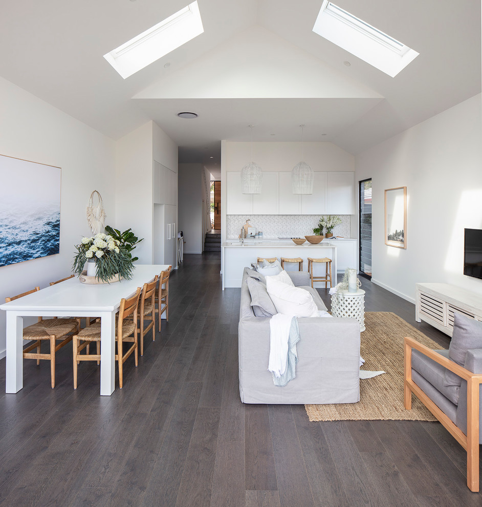 Small beach style open concept dark wood floor and brown floor living room photo in Sydney with white walls and a wall-mounted tv