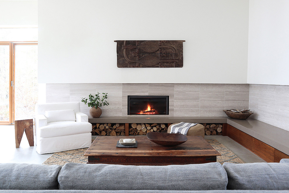 Inspiration for a large rustic open plan living room in Toronto with white walls, concrete flooring, a tiled fireplace surround, grey floors and a hanging fireplace.