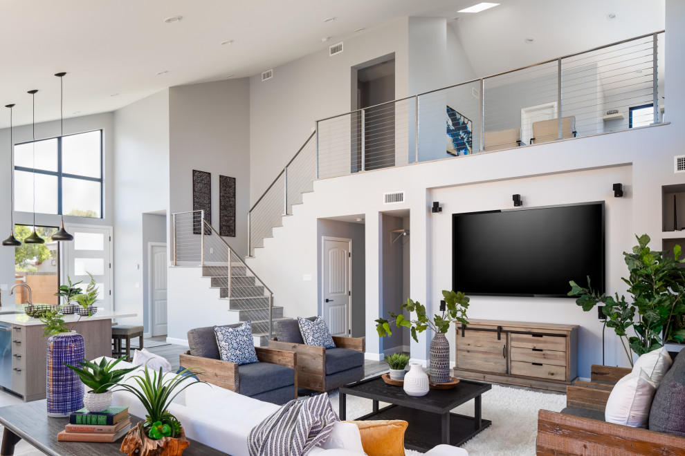 This is an example of a contemporary open plan living room in San Diego with grey walls, laminate floors and a wall mounted tv.