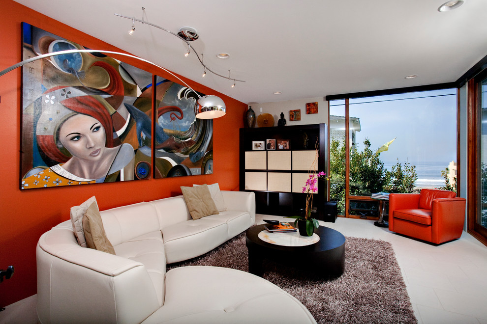 На фото: маленькая открытая гостиная комната в современном стиле с полом из известняка, скрытым телевизором и оранжевыми стенами для на участке и в саду с