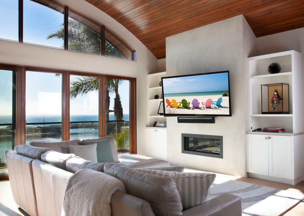 サンディエゴにあるトランジショナルスタイルのおしゃれなLDK (白い壁、大理石の床、コンクリートの暖炉まわり、壁掛け型テレビ、茶色い床、三角天井、板張り天井) の写真