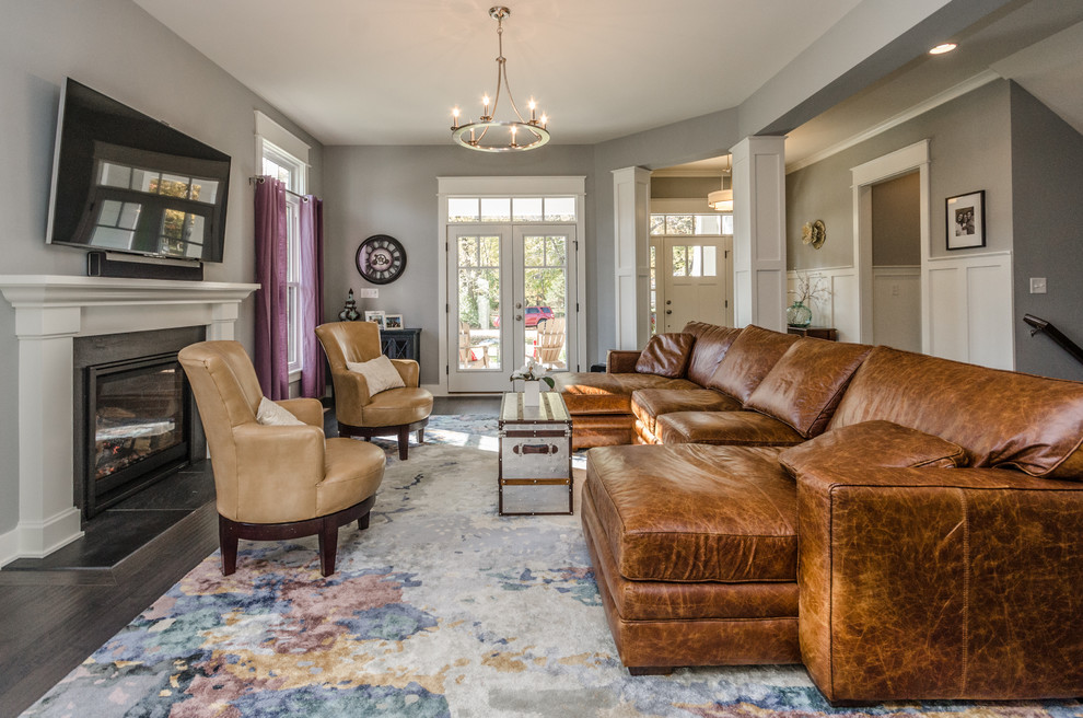 Living room - transitional dark wood floor and brown floor living room idea in Indianapolis with gray walls, a standard fireplace and a wall-mounted tv