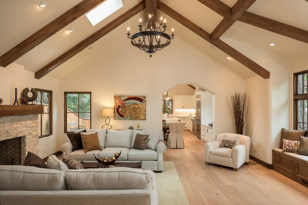Klassisches Wohnzimmer mit beiger Wandfarbe, hellem Holzboden, Kamin, Kaminumrandung aus Stein und beigem Boden in Sonstige