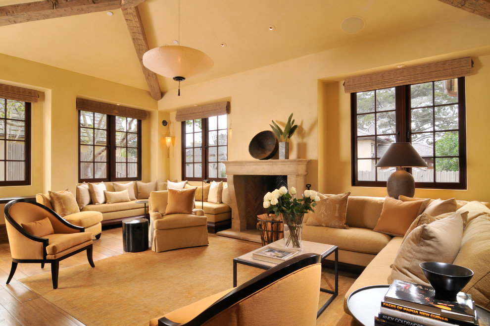 Источник вдохновения для домашнего уюта: гостиная комната в средиземноморском стиле с желтыми стенами, паркетным полом среднего тона и стандартным камином без телевизора