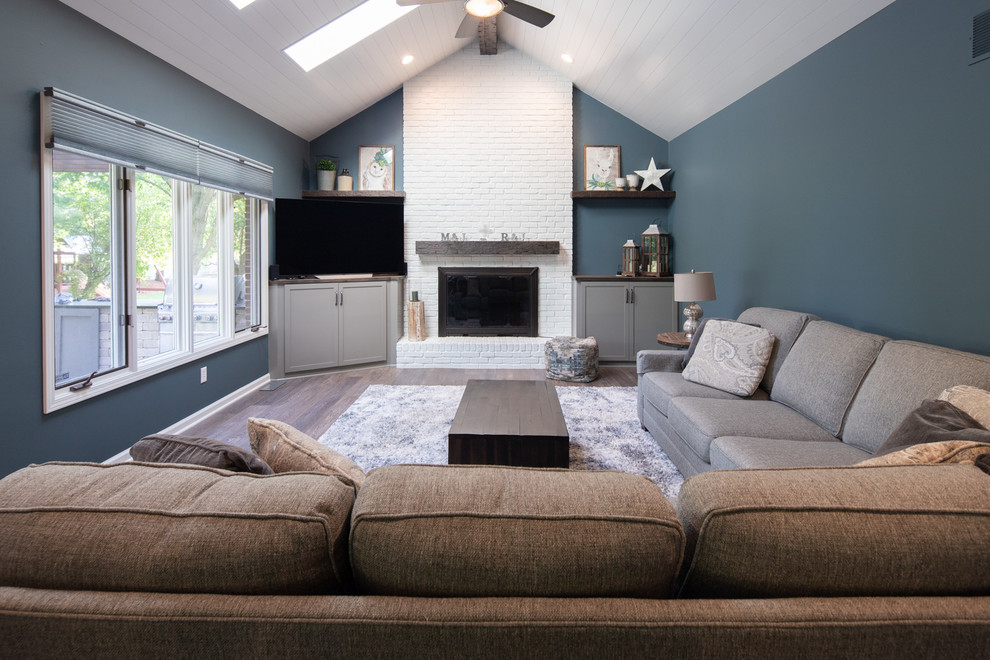 インディアナポリスにあるお手頃価格の中くらいなトランジショナルスタイルのおしゃれなLDK (青い壁、濃色無垢フローリング、標準型暖炉、レンガの暖炉まわり、壁掛け型テレビ、茶色い床) の写真