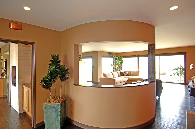 Cette image montre un grand salon design ouvert avec un mur beige et parquet foncé.