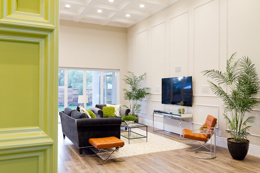 Esempio di un grande soggiorno minimalista aperto con pavimento in legno massello medio, TV a parete, pareti beige, nessun camino e pavimento marrone