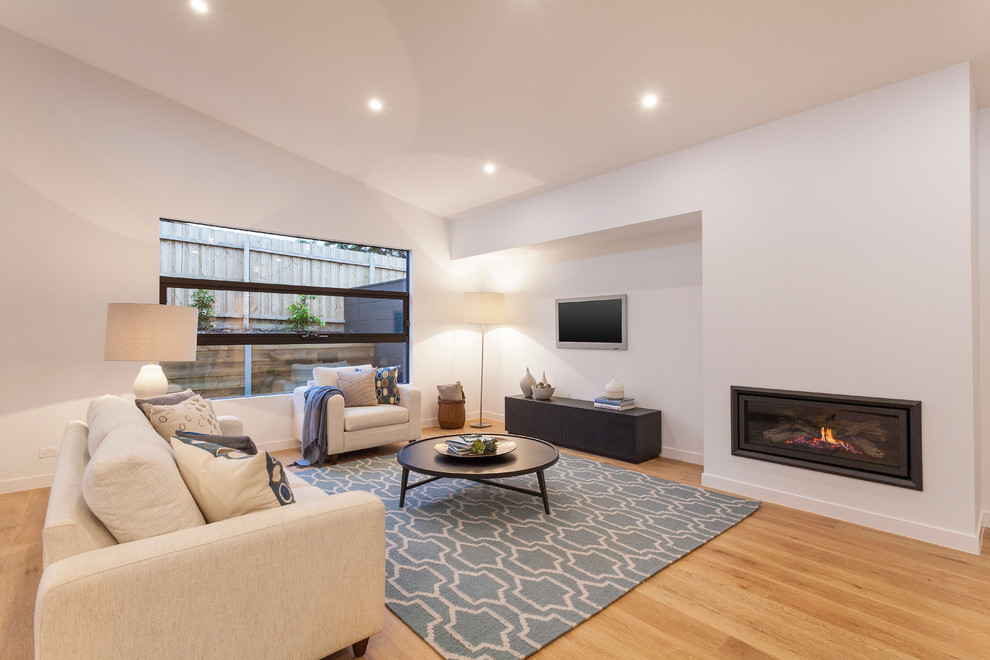 Inspiration for a mid-sized contemporary enclosed carpeted living room remodel in Melbourne with white walls, a standard fireplace, a metal fireplace and a tv stand
