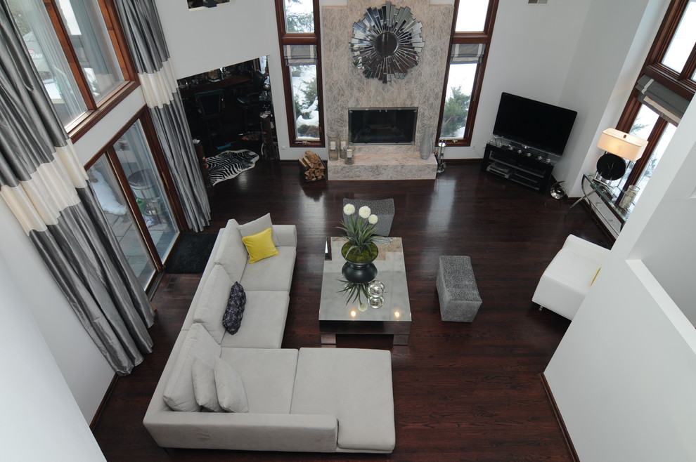 Cette photo montre un grand salon moderne ouvert avec un mur blanc, un sol en bois brun, une cheminée standard, un manteau de cheminée en pierre et un téléviseur indépendant.