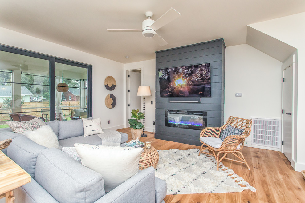 На фото: гостиная комната в стиле кантри с паркетным полом среднего тона и телевизором на стене с