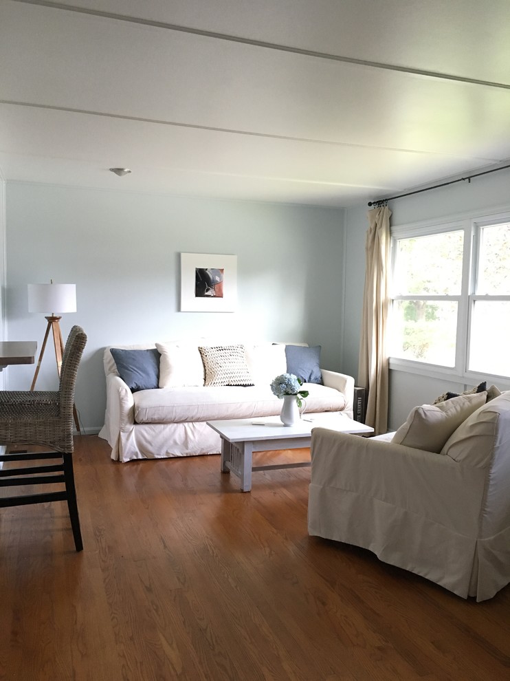 Diseño de salón abierto tradicional renovado pequeño con paredes azules y suelo de madera en tonos medios