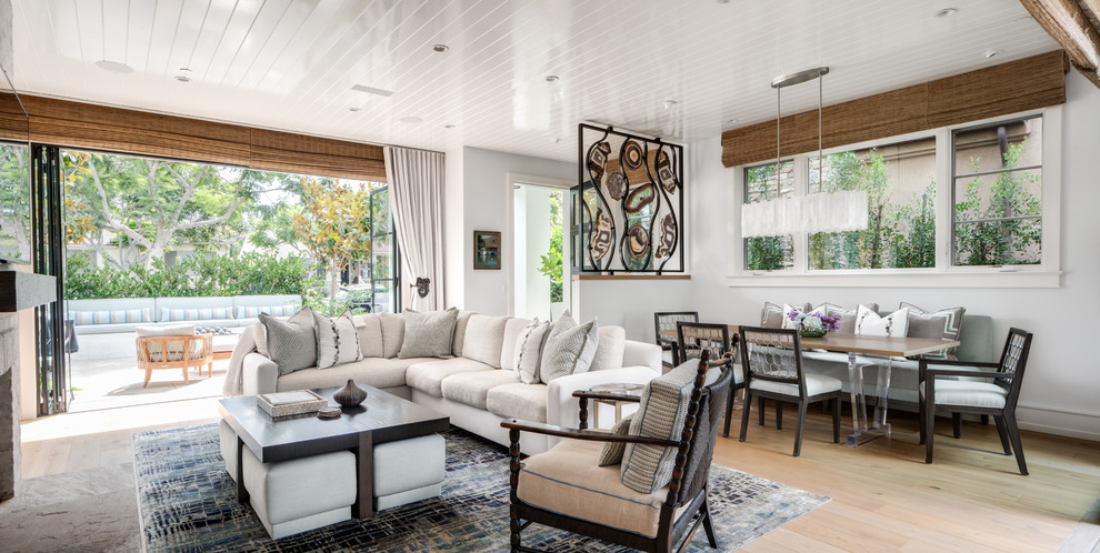 Immagine di un grande soggiorno contemporaneo aperto con pareti bianche, parquet chiaro, camino classico, TV a parete e pavimento beige