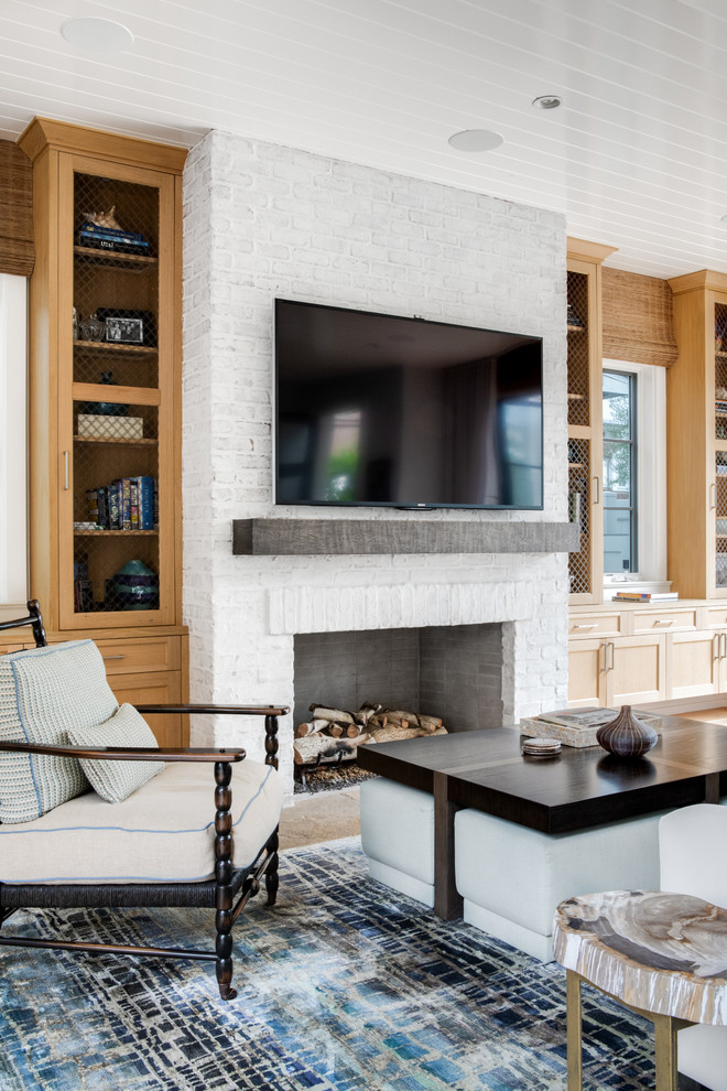 Cette image montre un grand salon design ouvert avec un mur blanc, parquet clair, une cheminée standard, un manteau de cheminée en brique, un téléviseur fixé au mur et un sol beige.