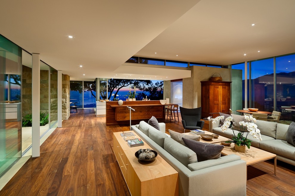 Contemporary open plan living room in Santa Barbara with beige walls, medium hardwood flooring and brown floors.