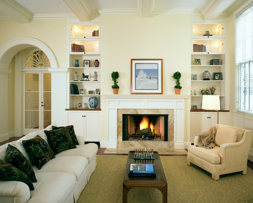 Foto de salón clásico con marco de chimenea de piedra y paredes amarillas