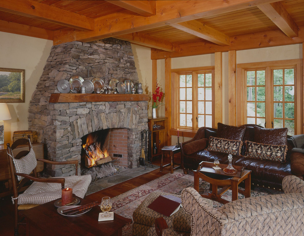 Ejemplo de salón abierto tradicional con paredes amarillas, suelo de madera en tonos medios, todas las chimeneas y marco de chimenea de piedra