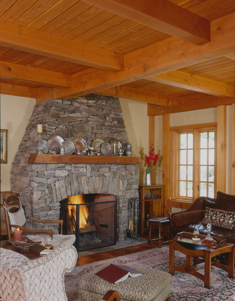 Offenes Klassisches Wohnzimmer mit gelber Wandfarbe, braunem Holzboden, Kamin und Kaminumrandung aus Stein in Boston