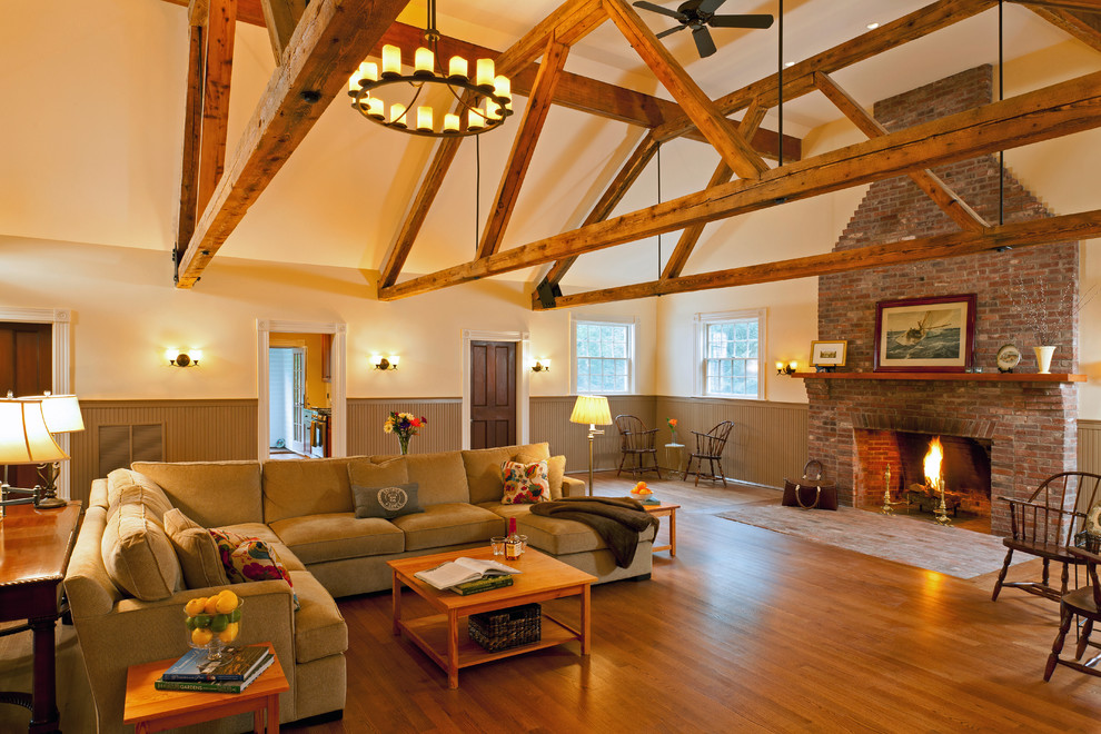 Diseño de salón clásico con paredes beige, suelo de madera en tonos medios, todas las chimeneas y marco de chimenea de ladrillo