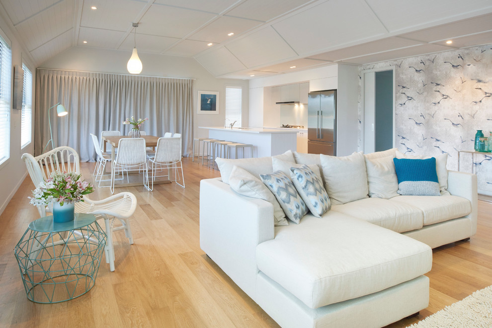 Offenes, Mittelgroßes Wohnzimmer ohne Kamin mit hellem Holzboden und bunten Wänden in Auckland