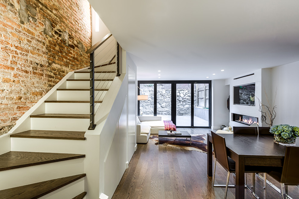 Mittelgroßes, Repräsentatives, Offenes Modernes Wohnzimmer mit weißer Wandfarbe, braunem Holzboden, Hängekamin, verputzter Kaminumrandung, Multimediawand und braunem Boden in New York