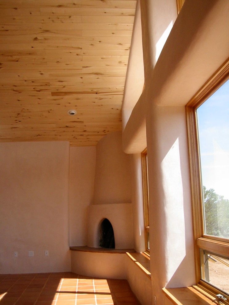 Diseño de salón abierto bohemio de tamaño medio con paredes beige, suelo de baldosas de terracota, chimenea de esquina y marco de chimenea de yeso