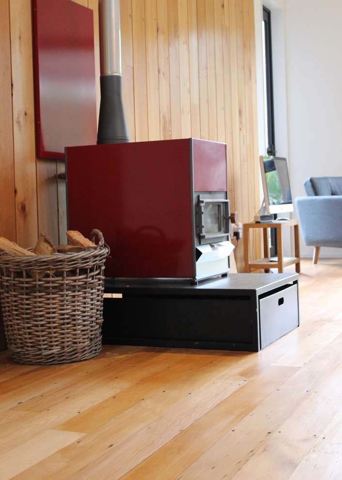 Modernes Wohnzimmer mit hellem Holzboden und Kaminumrandung aus Holz in Auckland