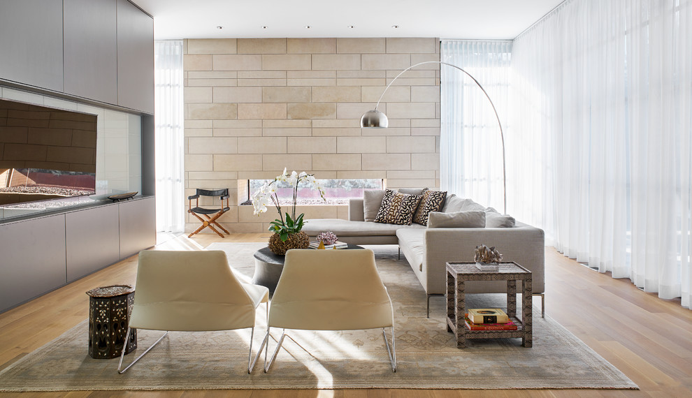 Источник вдохновения для домашнего уюта: большая открытая гостиная комната в современном стиле с серыми стенами, светлым паркетным полом и телевизором на стене без камина