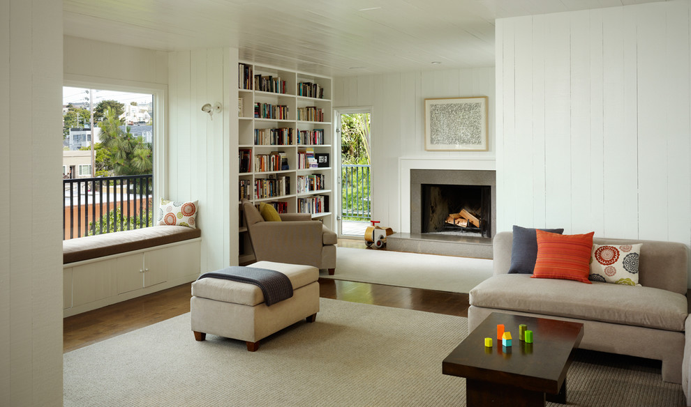 На фото: гостиная комната в современном стиле с с книжными шкафами и полками, стандартным камином и ковром на полу