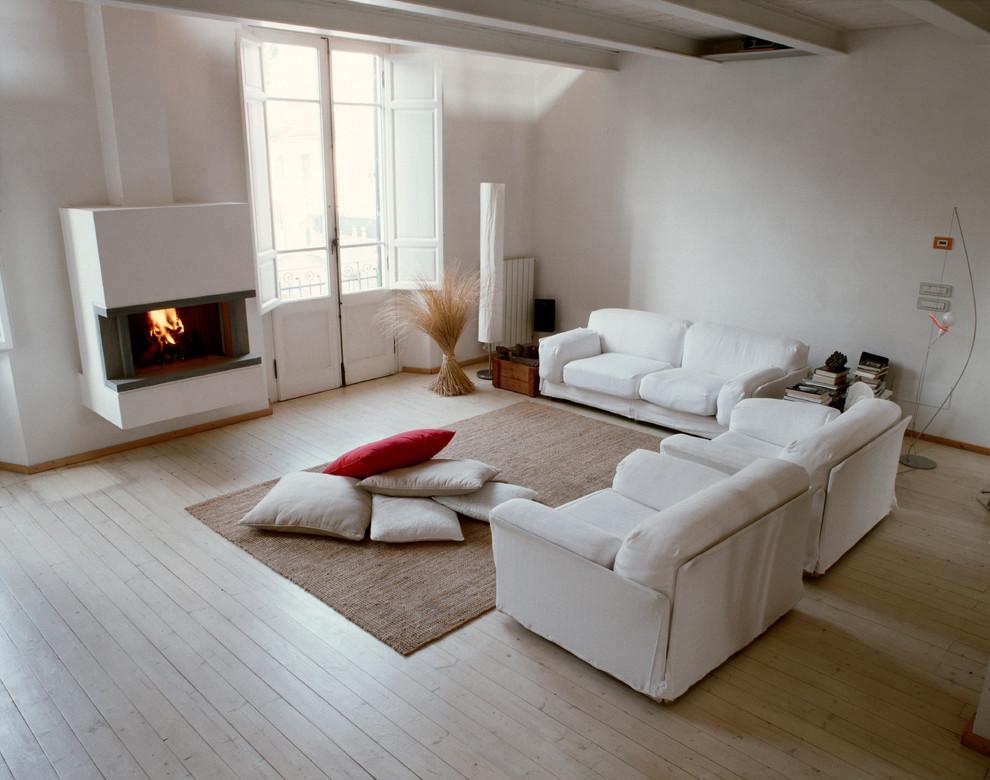 Ejemplo de salón contemporáneo con paredes blancas, suelo de madera clara, chimenea lineal y marco de chimenea de yeso