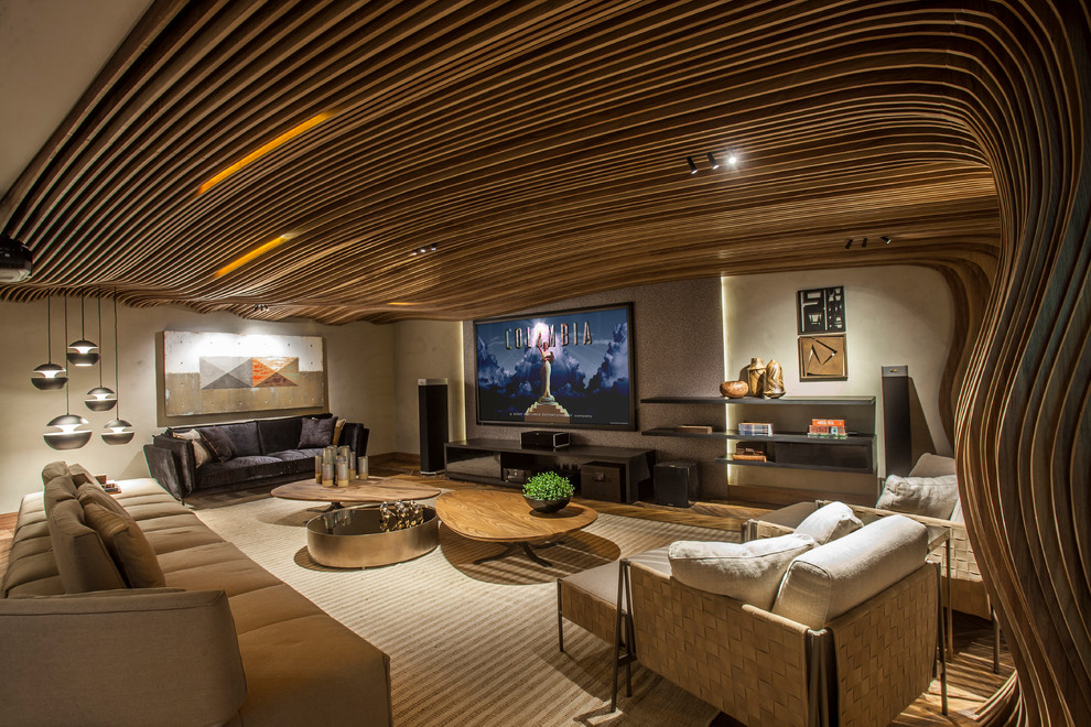 Immagine di un soggiorno design con pareti beige, pavimento in legno massello medio, TV a parete e pavimento marrone