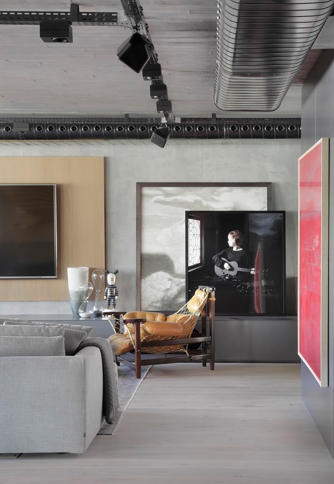 Modelo de salón actual con paredes grises, suelo de madera clara, televisor colgado en la pared y suelo beige