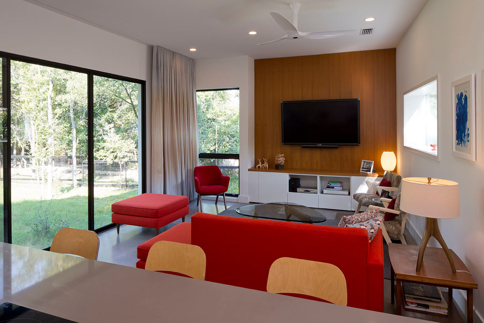 Kleines, Abgetrenntes Modernes Wohnzimmer ohne Kamin mit weißer Wandfarbe, Betonboden und TV-Wand in Austin