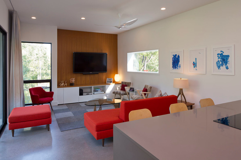 Идея дизайна: маленькая изолированная гостиная комната в современном стиле с белыми стенами, бетонным полом и телевизором на стене без камина для на участке и в саду