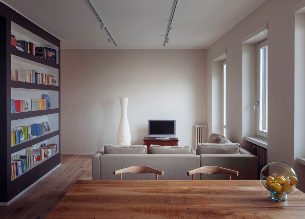 Inspiration för moderna allrum med öppen planlösning, med vita väggar, ljust trägolv och en fristående TV