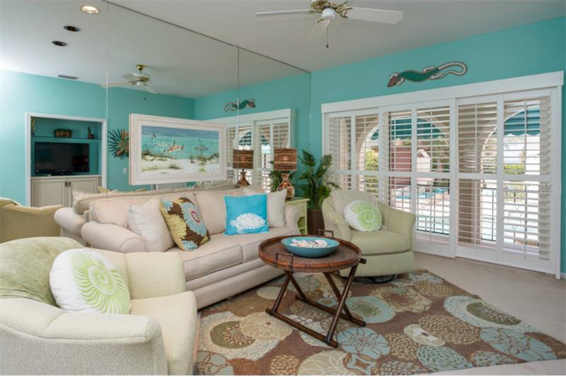 Mittelgroßes, Abgetrenntes Mediterranes Wohnzimmer ohne Kamin mit blauer Wandfarbe, Teppichboden und freistehendem TV in Tampa