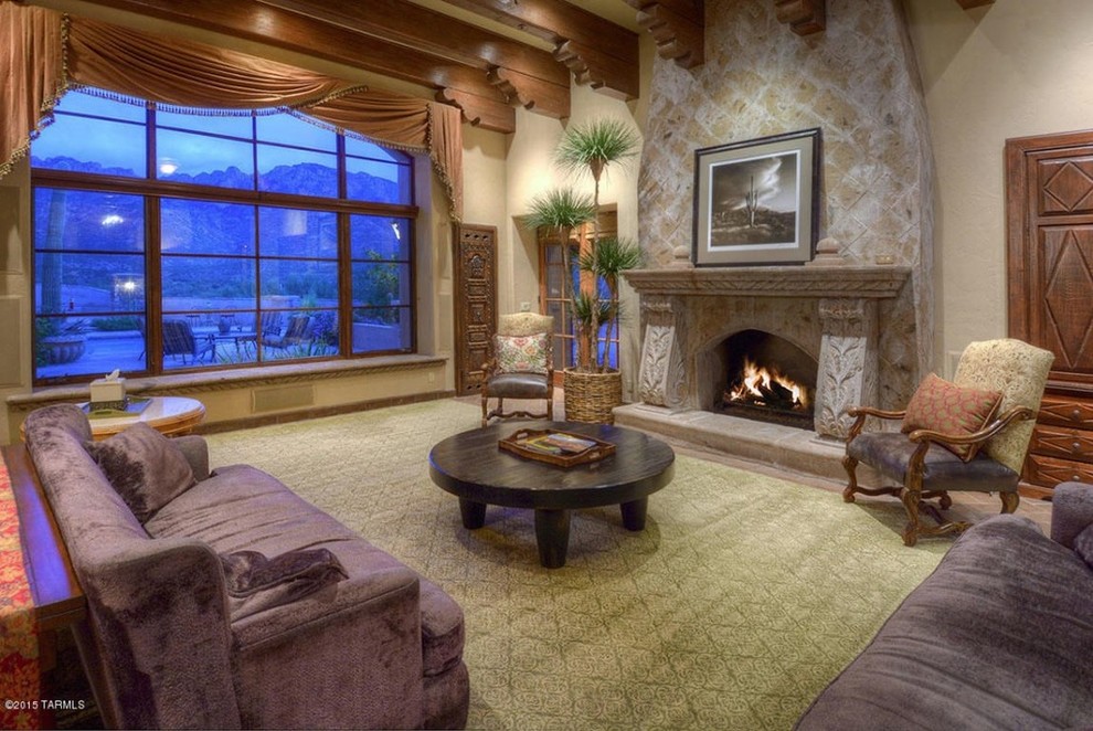 Photo of a rustic enclosed living room in San Diego with beige walls, terracotta flooring, a standard fireplace, a stone fireplace surround and a built-in media unit.