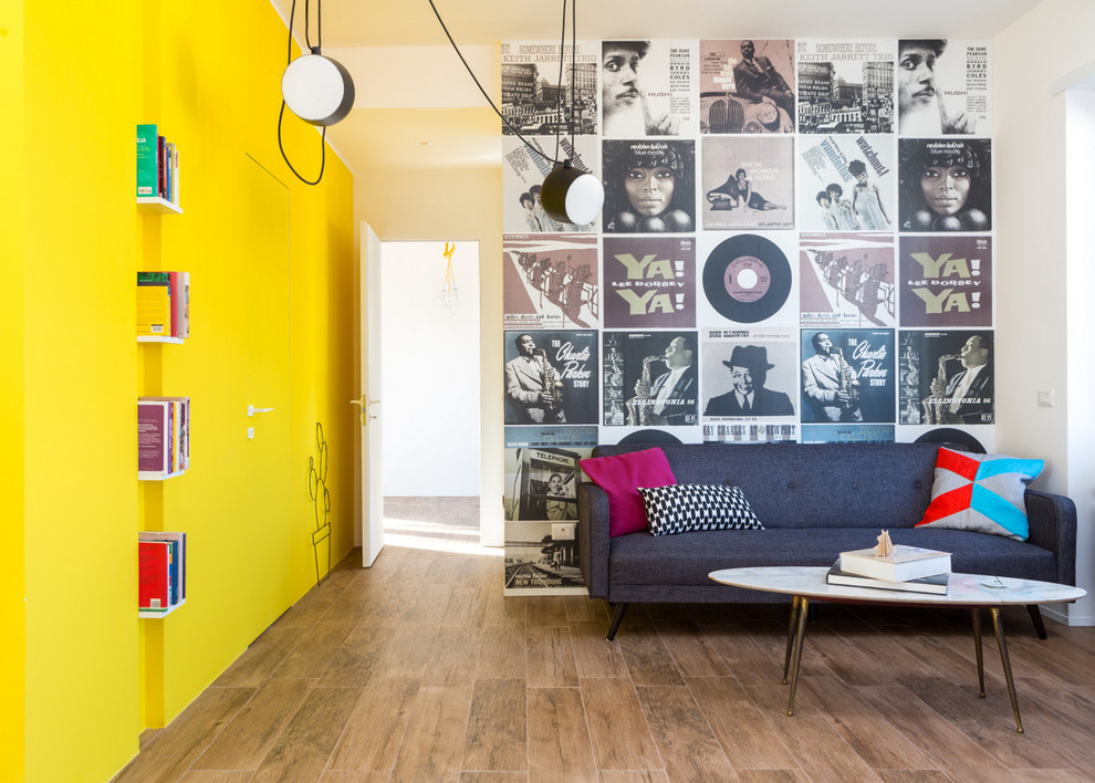 Immagine di un soggiorno design con pareti gialle e pavimento in legno massello medio