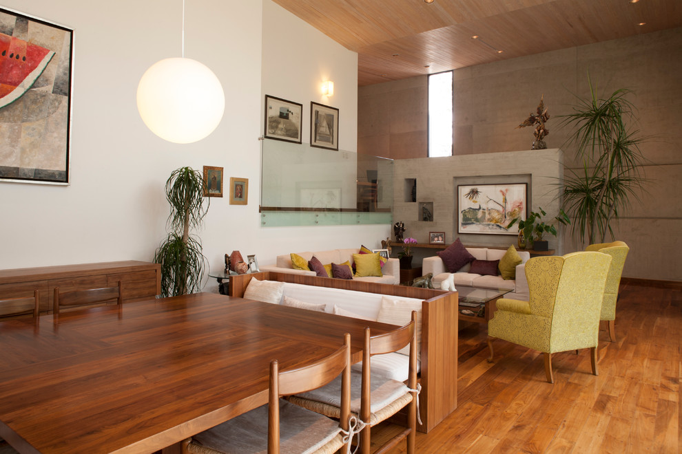 Example of a trendy medium tone wood floor living room design in Mexico City with white walls