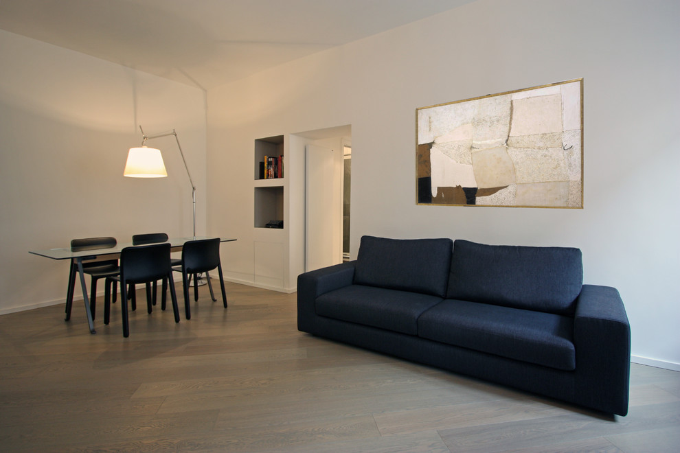 Foto di un piccolo soggiorno moderno aperto con libreria, pareti bianche, pavimento in legno massello medio e parete attrezzata